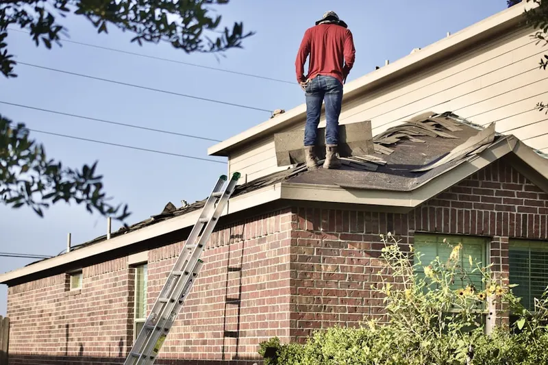 Professional roofer working on a residential roof in University Hills